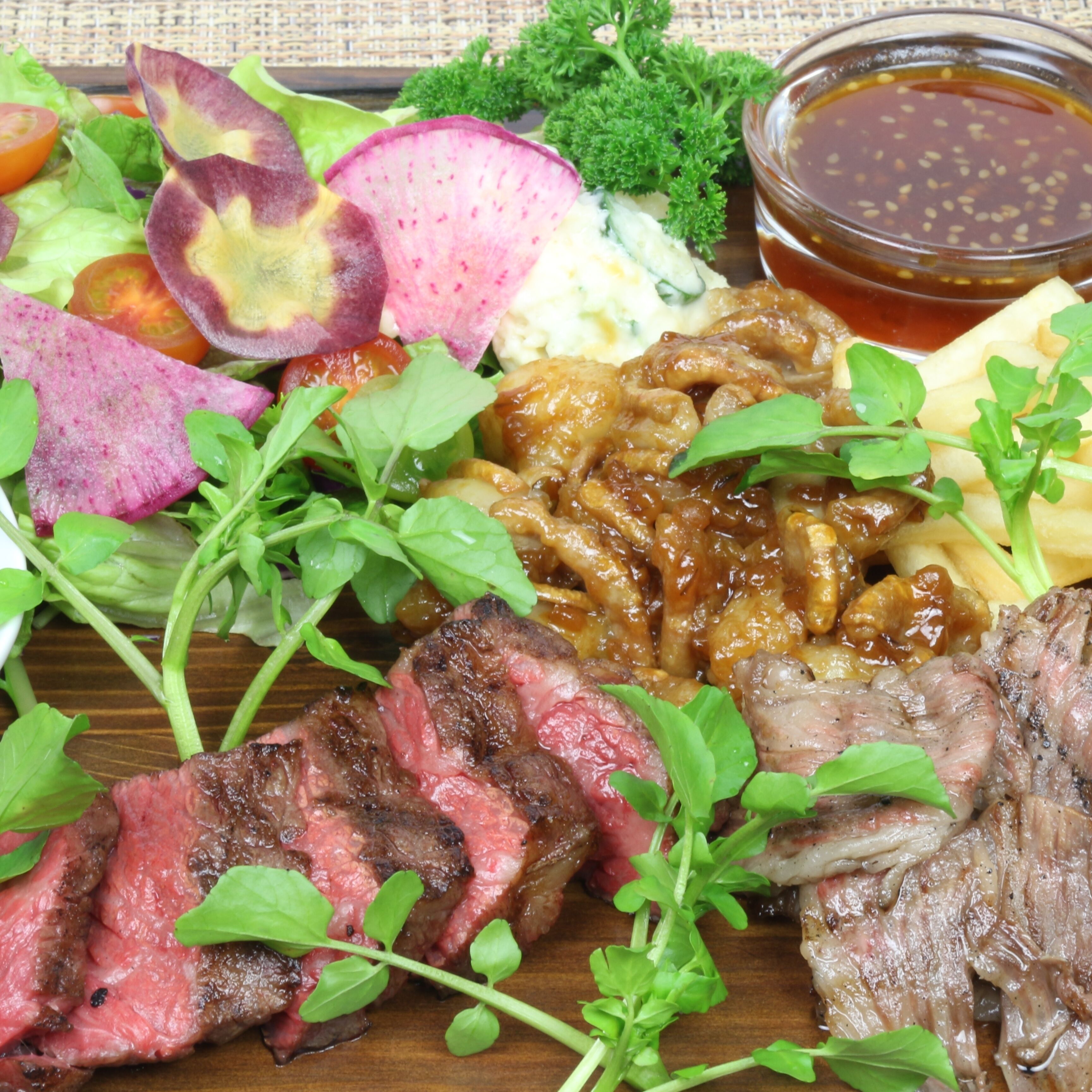 Una mesa de madera con diversos alimentos, como filete, verduras y un bol de salsa.