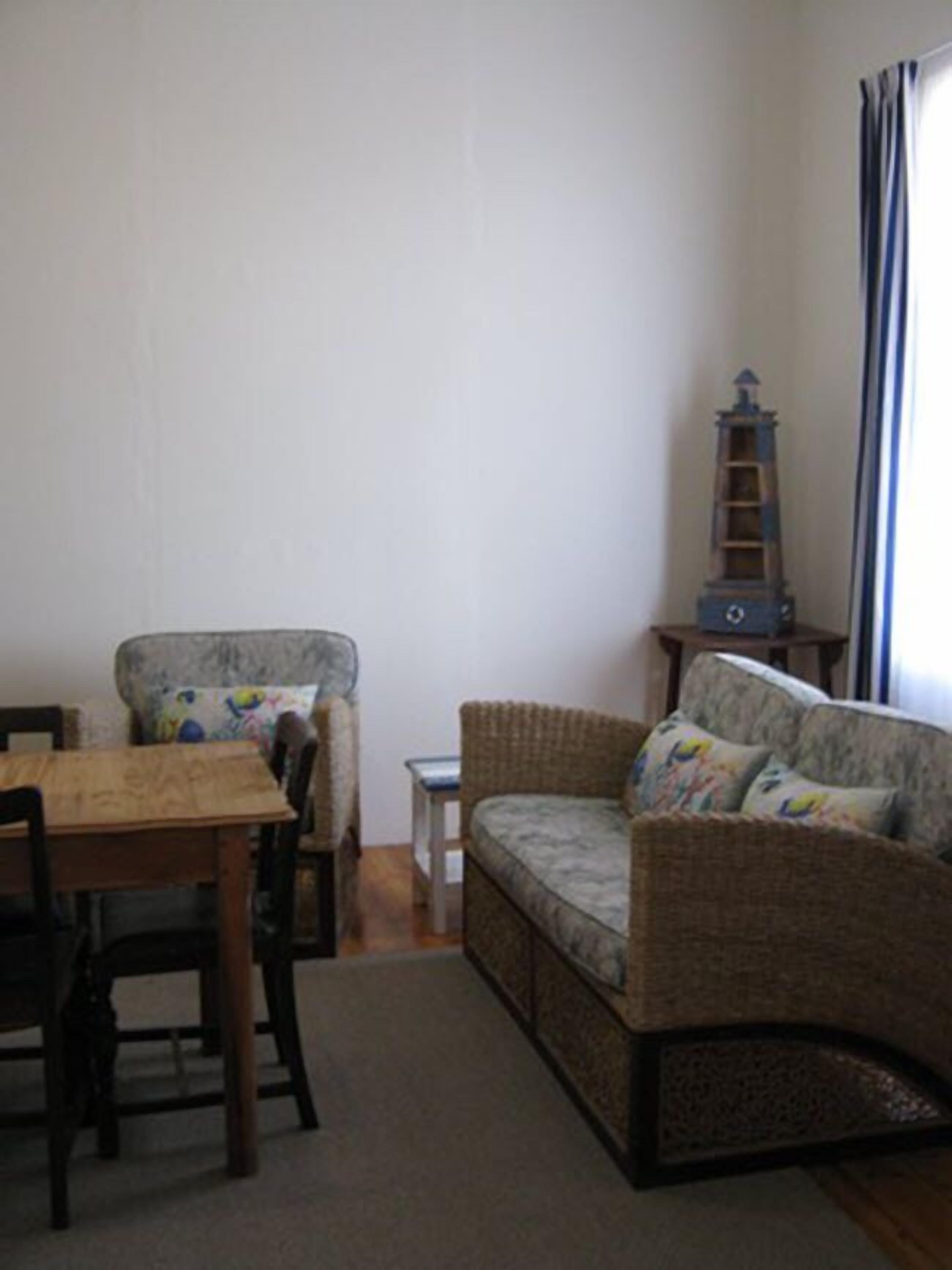 A living room with a sofa, a wooden table, and a small side table.