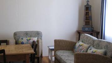 A living room with a sofa, a wooden table, and a small side table.