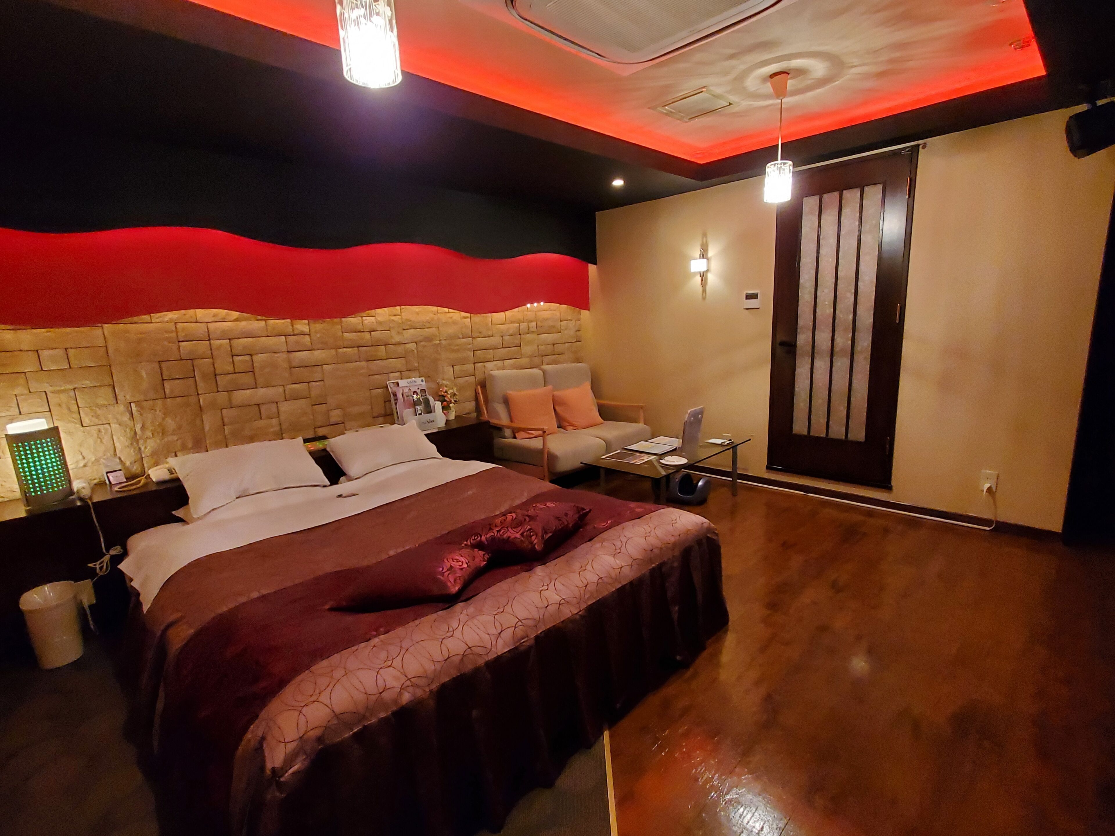 Una moderna camera d'albergo con un letto grande, un angolo salotto e una porta.
