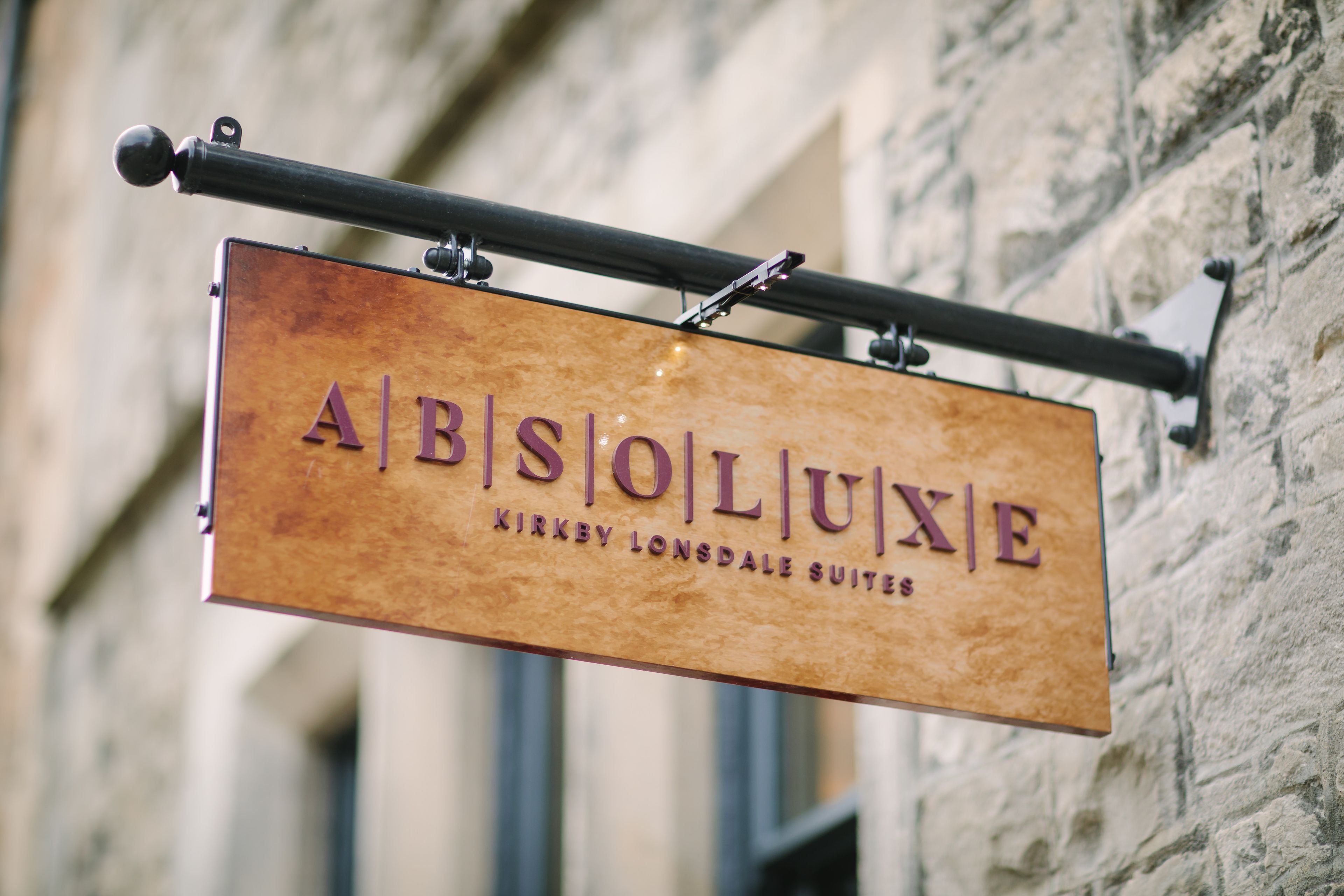 Ein Schild für das Hotel 'ABISOLUXE', das angibt, dass es sich um Suiten von Kirkby Lonsdale handelt.