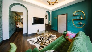A modern living room with a green sofa, a zebra-patterned rug, and a glass coffee table. - Absoluxe Suites (Carnforth)