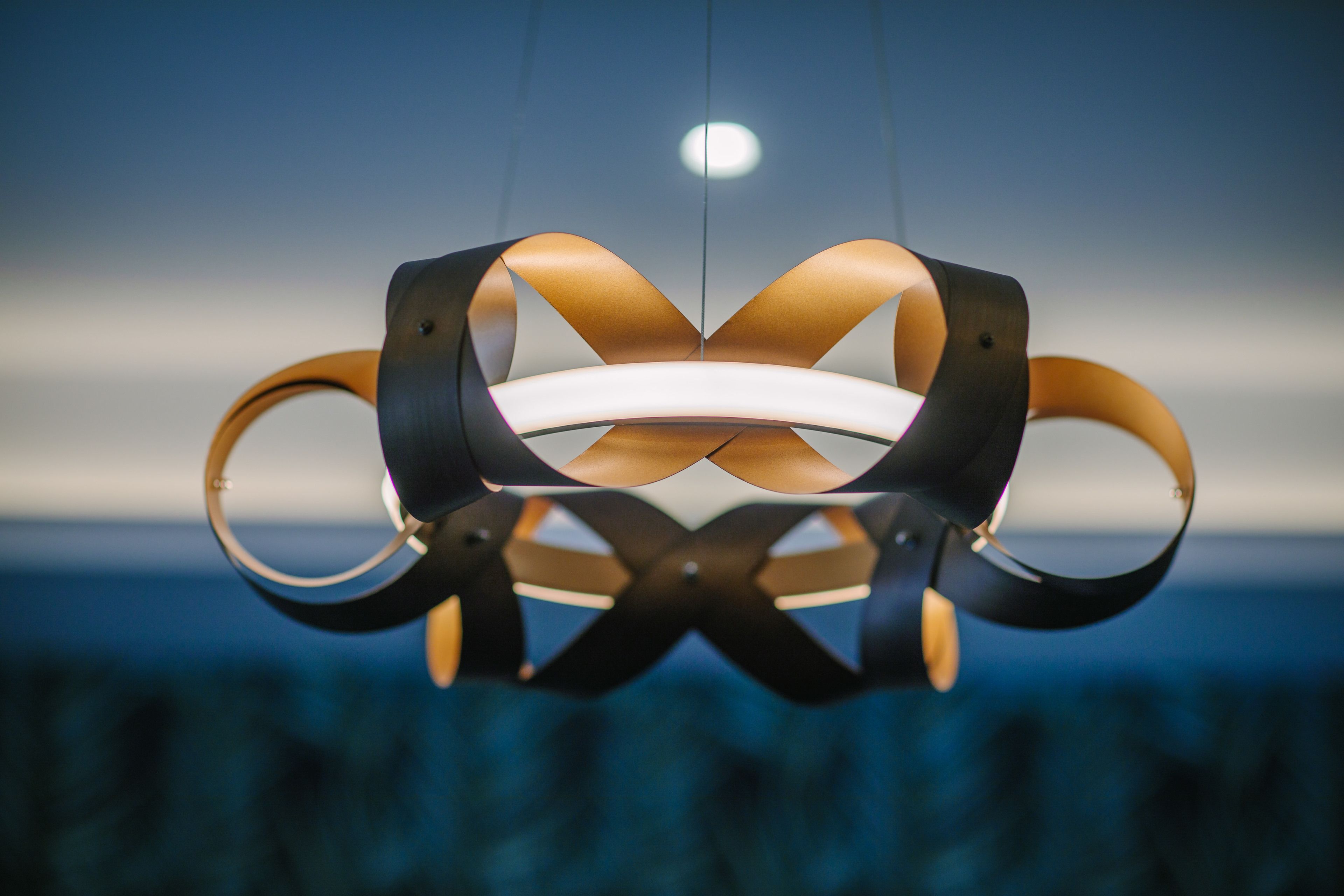Un lustre moderne au design circulaire, doté d’une source de lumière centrale.
