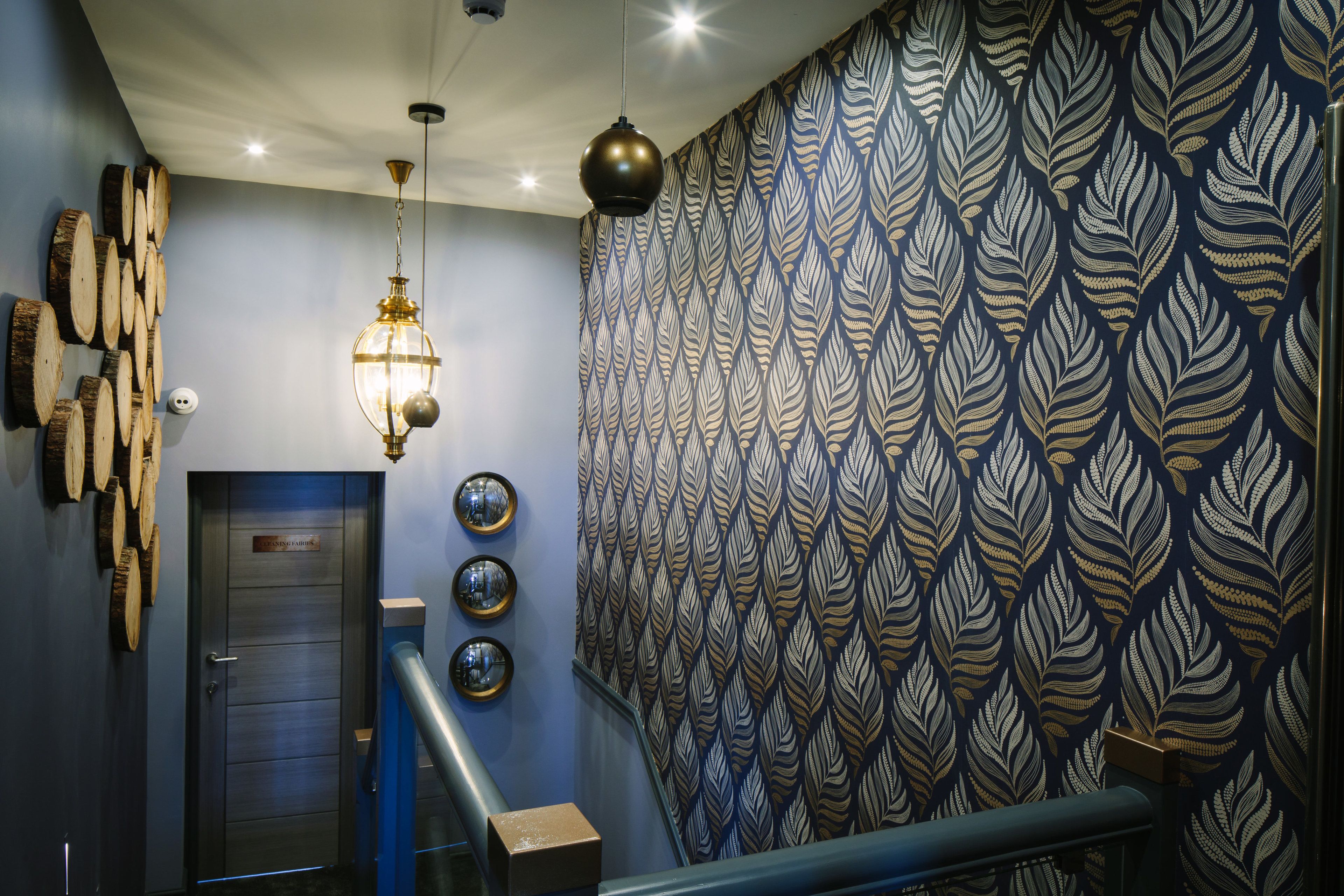 A modern interior with a patterned wallpaper, a staircase, and a door labeled "Executive Suites".