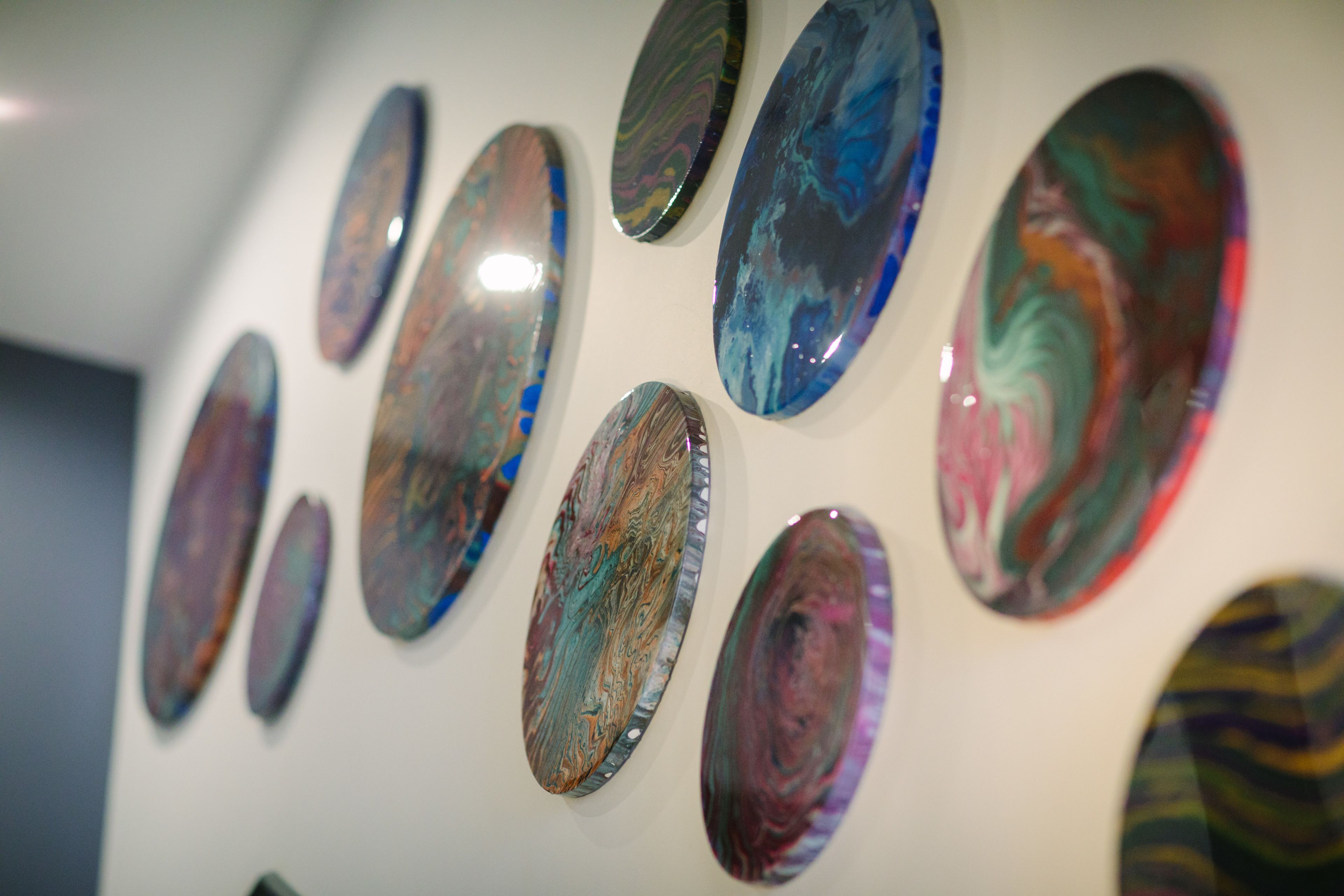 A wall with multiple oval-shaped artworks.
