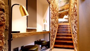 Een moderne badkamer met een houten bankje, een spiegel en een lamp.