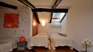 A small, cozy room with two beds, a skylight, a wall-mounted heater, and a single artwork. - Bloom 37 (Arzachena)