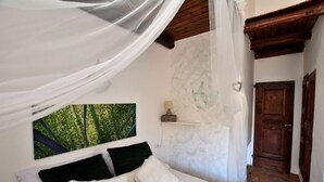 Un dormitorio con cama, repisa en la pared y una puerta.