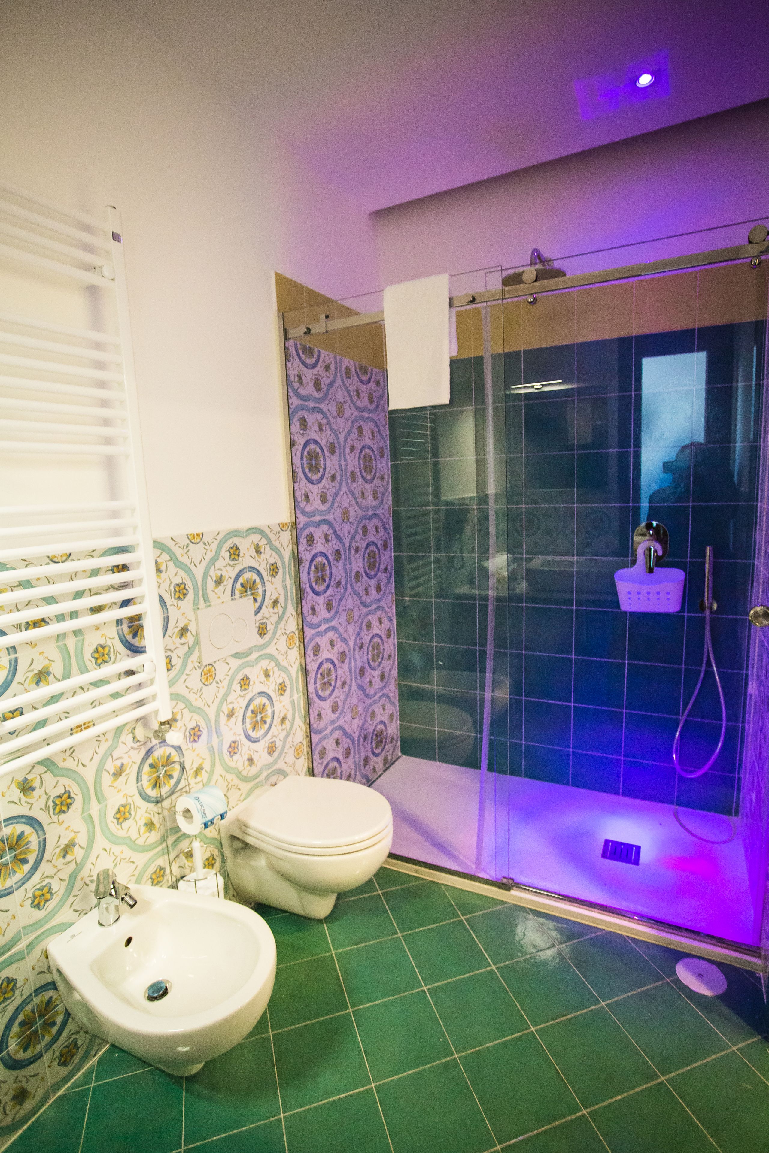 A bathroom with a shower, a bidet, and a toilet.