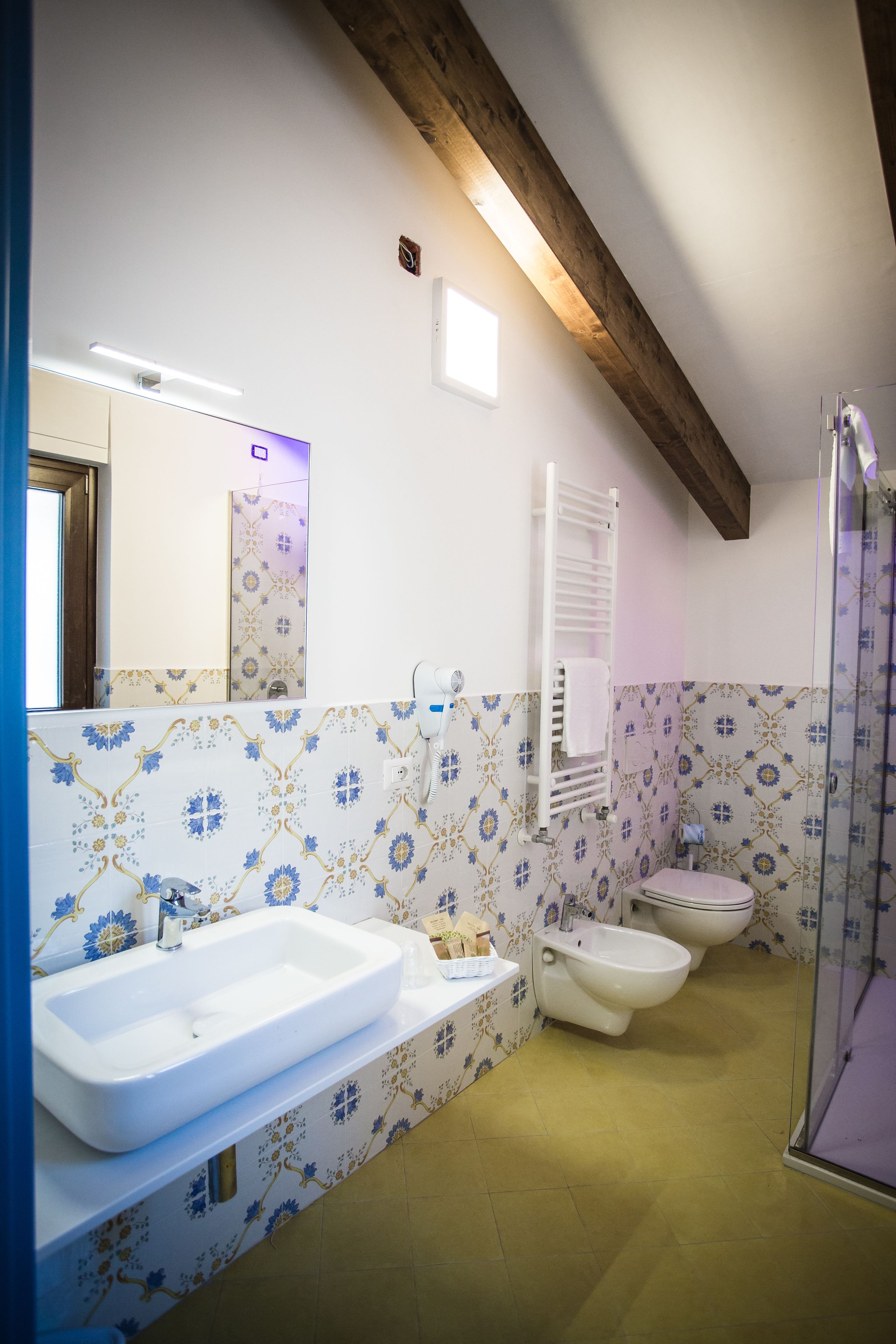 Une salle de bain dotée d’un grand lavabo, d’un bidet et d’une douche à parois en verre.