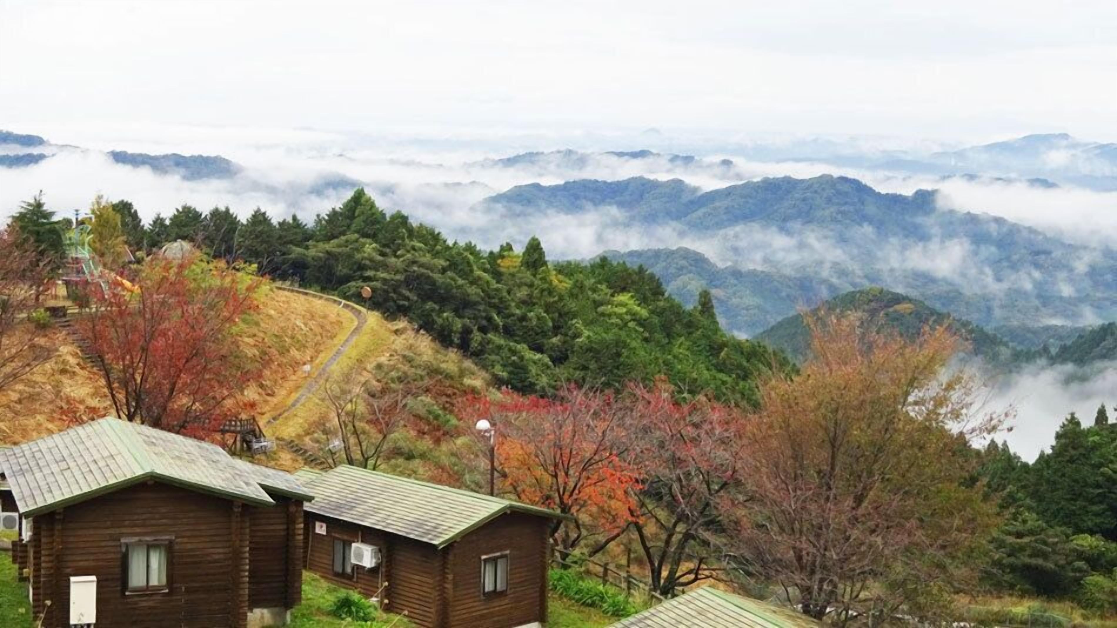 A mountainous landscape with cabins and a winding path.