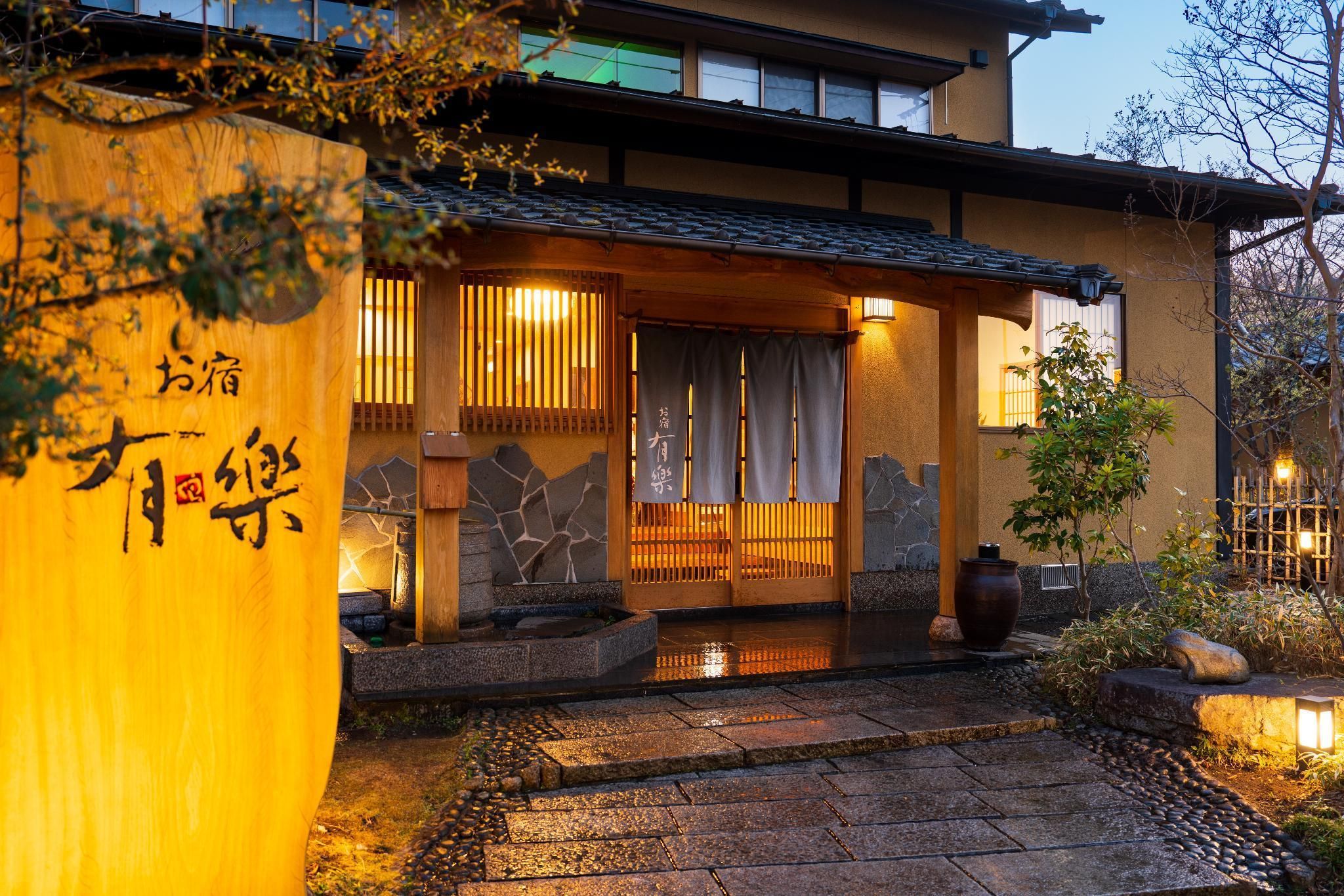 Ein traditionelles japanisches Gebäude mit einem Kiesweg, der zu einem hölzernen Eingang führt.