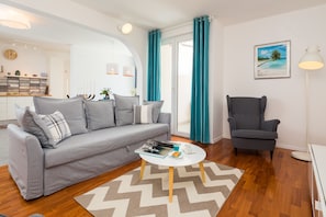 Relax in this stylish living room with a sofa, armchair, and floor lamp.