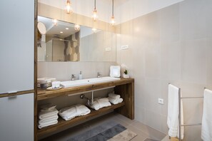 A modern bathroom with a wooden vanity, a large mirror, and a towel rack. - Sun Spalato Garden (Split)
