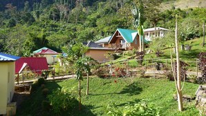 A rural setting with houses, a garden, and a hilly backdrop. - Karibotel (Antananarivo)
