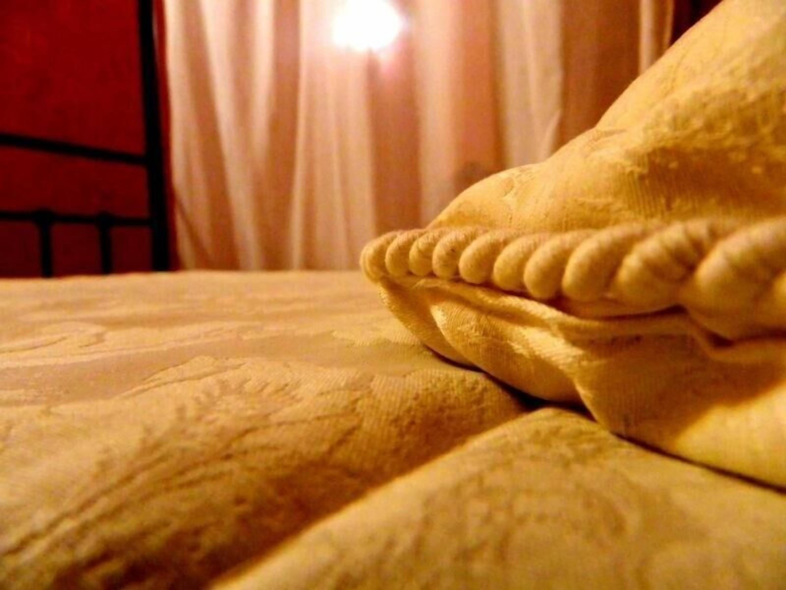 Un lit avec une couverture à motifs et une tête de lit.