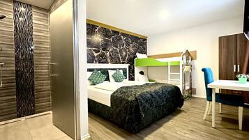 Habitación cuádruple Deluxe | Escritorio, wifi gratis y ropa de cama