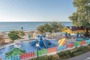 Una piscina techada, una piscina al aire libre, sombrillas