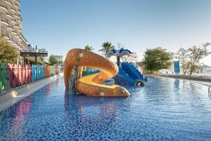 Una piscina techada, una piscina al aire libre, sombrillas