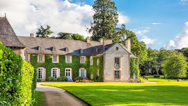 A large stone building with a symmetrical facade, a central entrance, and a well-maintained lawn. - Château de la Villedubois (Mordelles)