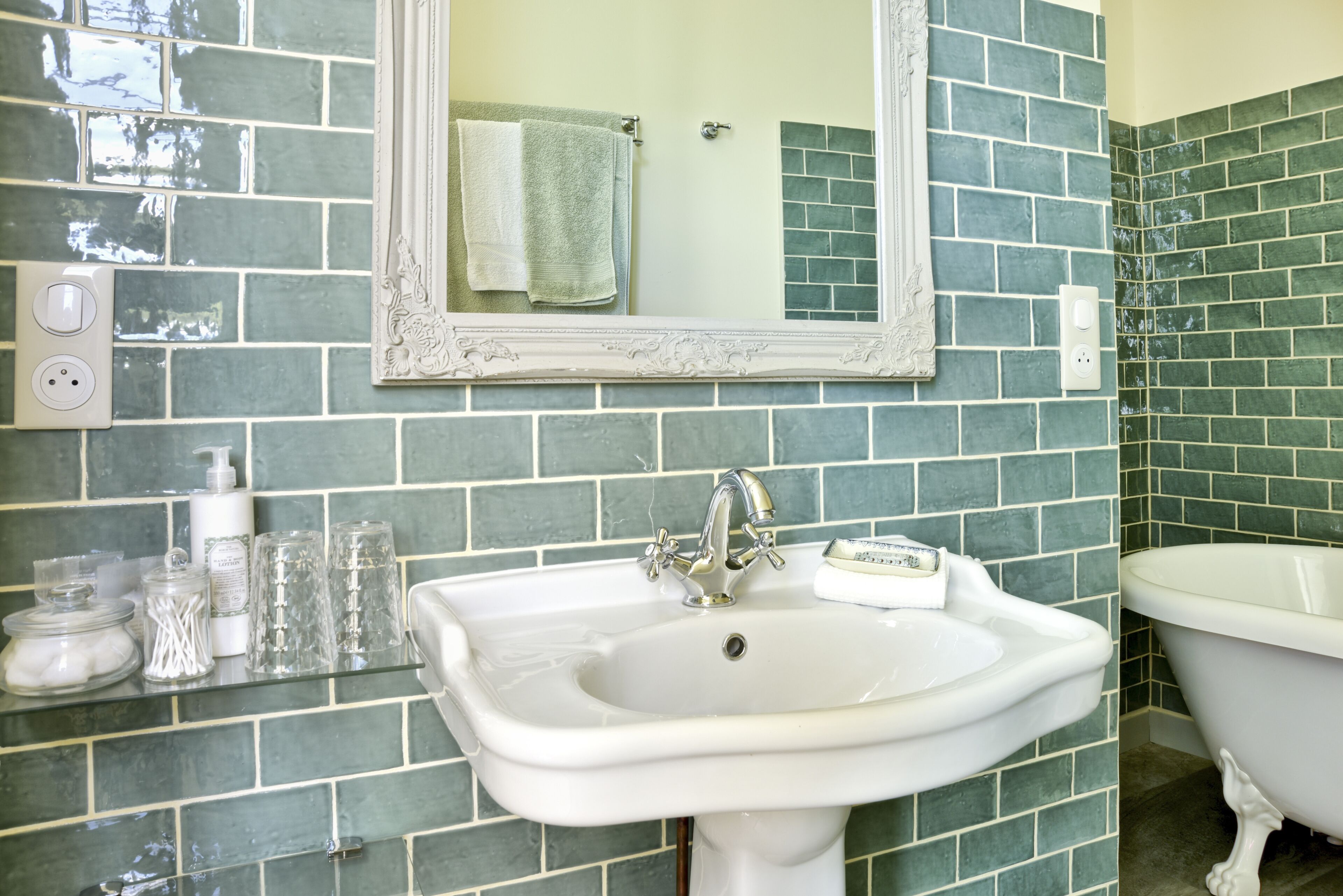 A bathroom with a white sink, a mirror, and a bathtub.