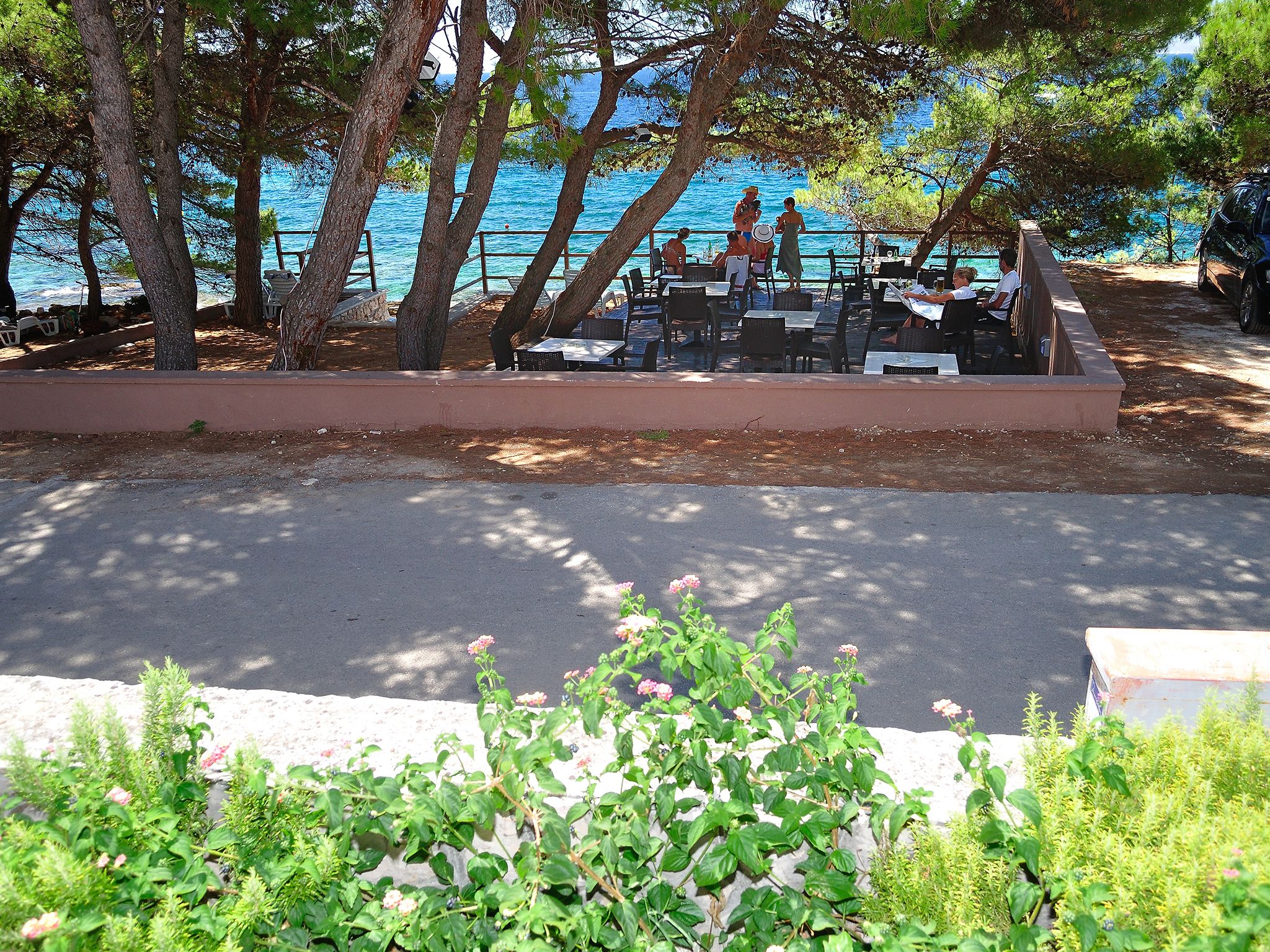 An outdoor seating area with tables and chairs, overlooking a body of water.