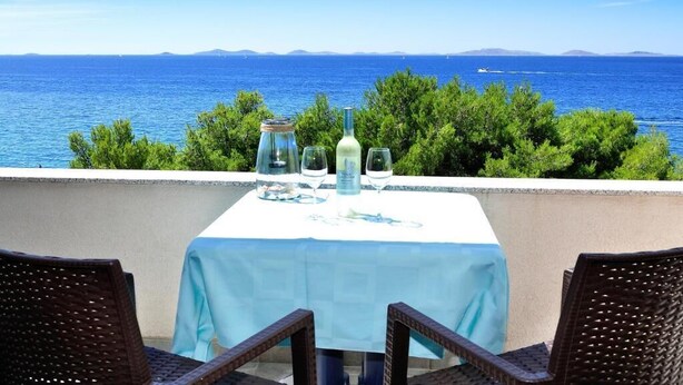 Una mesa para dos con vistas al mar y a islas distantes.