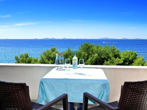 Una mesa para dos con vistas al mar y a islas distantes.