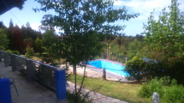 Vista de una piscina rodeada de árboles y una valla.