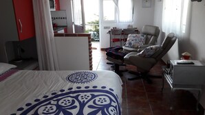 Una habitación de hotel con cama, una silla, un escritorio y una ventana.