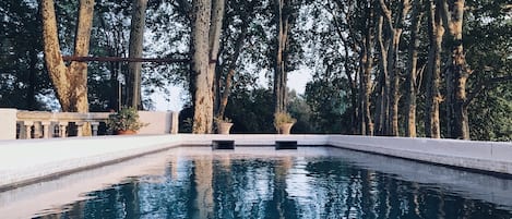 Una piscina al aire libre de temporada, tumbonas