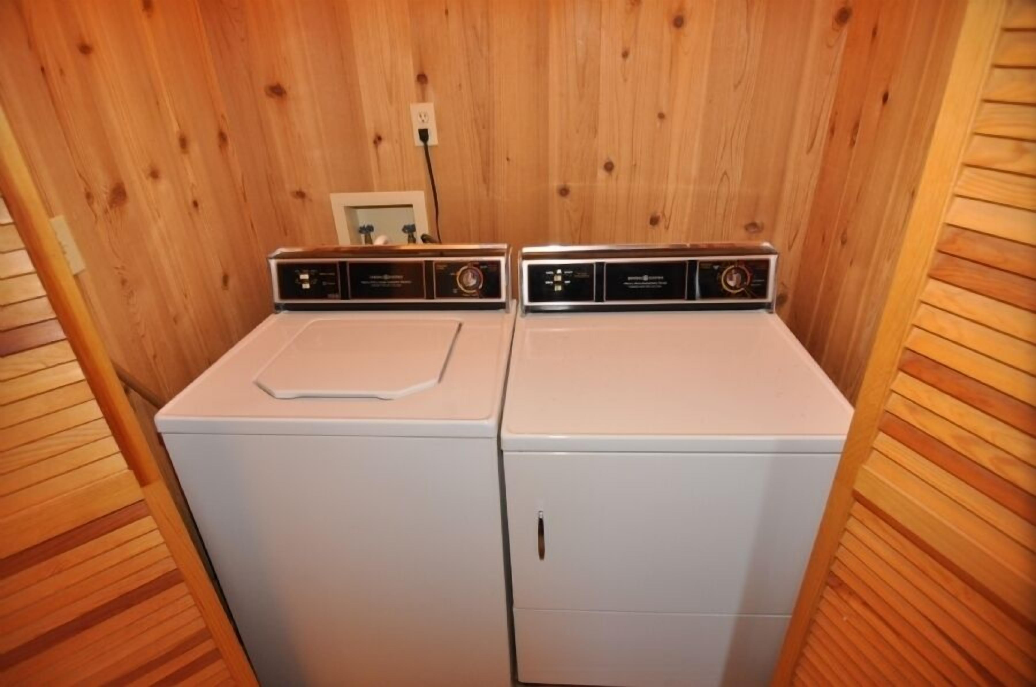 A laundry room with two white washing machines.