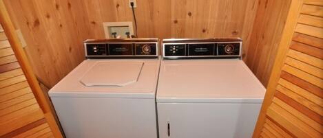 A laundry room with two white washing machines.