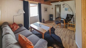 A cozy living room with a sofa, a wooden coffee table, and a black dog lying on the floor.
