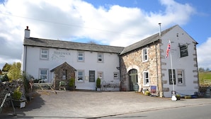 A two-story building with a stone facade and a sign for 'Herdwick Inn'. - The Herdwick Inn (Penrith)