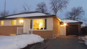 A two-story house with a snow-covered roof and a garage.