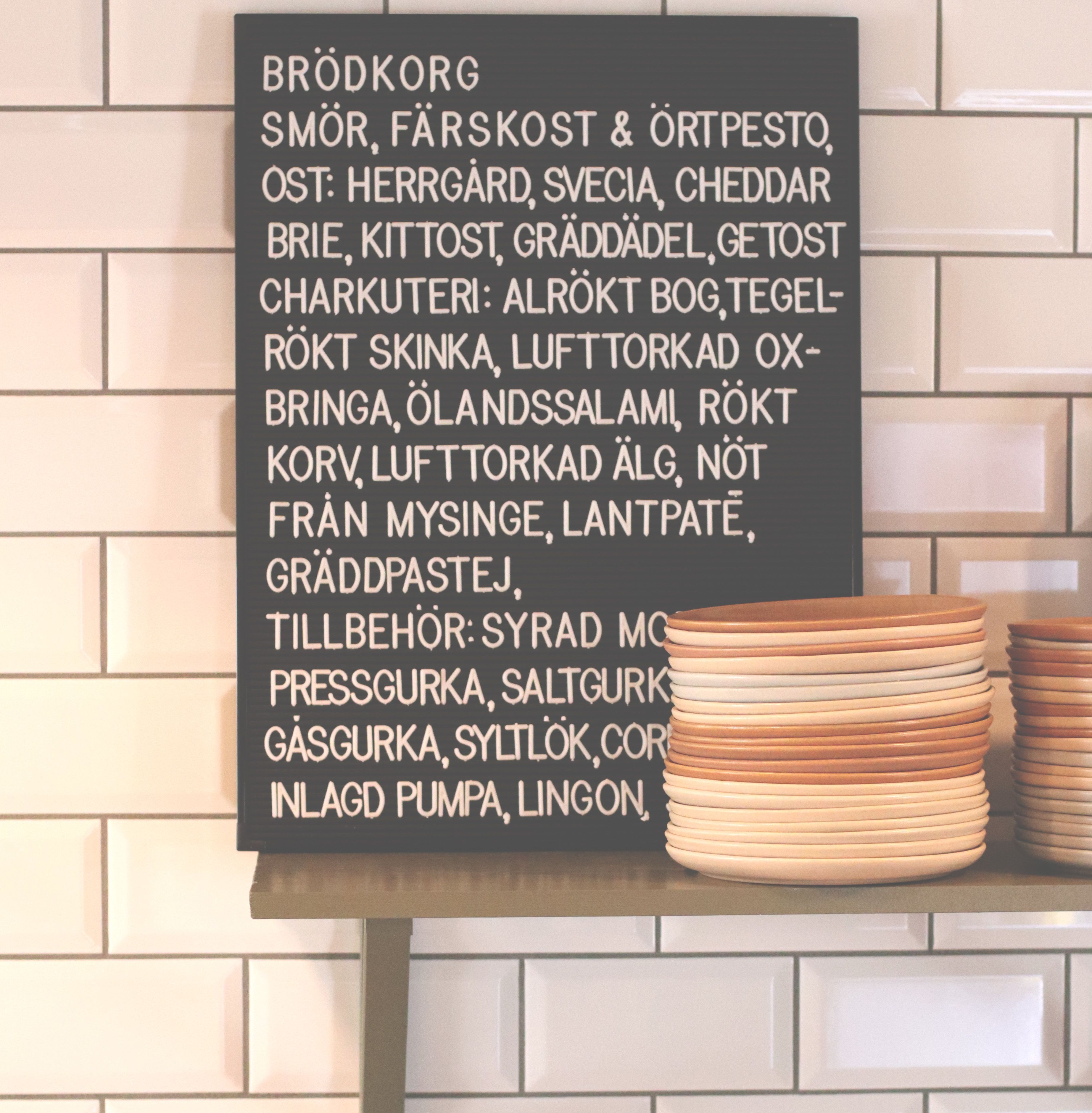 A menu board with a list of food items and beverages.