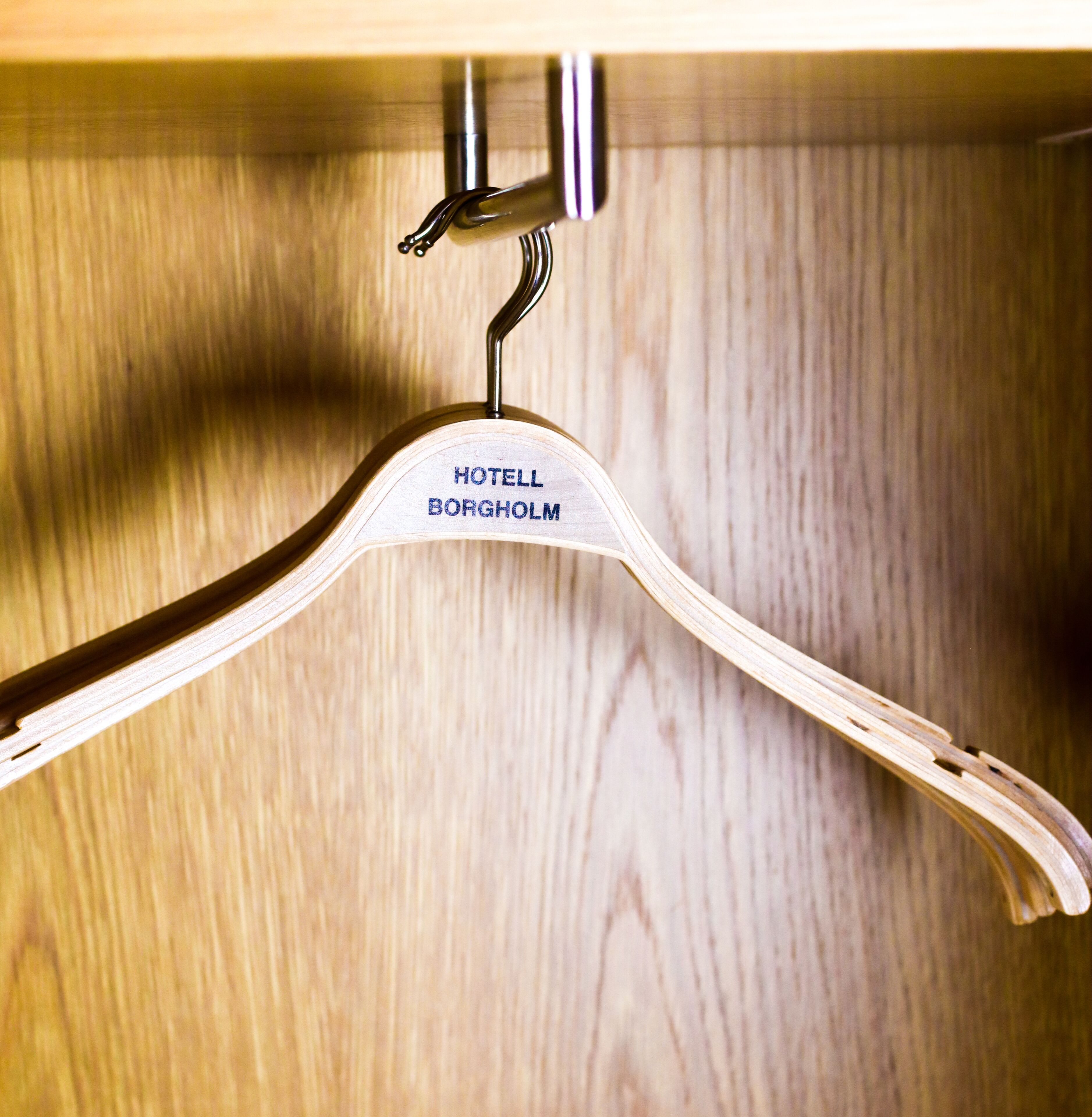 A wooden hanger with the text "HOTELL BORGHOLM" on it.