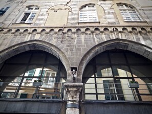 Um edifício histórico com duas grandes janelas em arco e fachada de pedra.