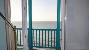 A view from a balcony with a railing, overlooking a body of water.