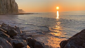 A sunset over a rocky coastline with cliffs.