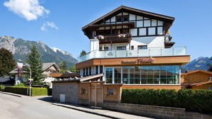 A hotel with a mountain view, a balcony with flowers, and a sign for Restaurant Filser. - Hotel Filser (Oberstdorf)