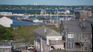 A marina with boats docked, surrounded by residential buildings and a clear sky. - The Outlook Inn (Newport)