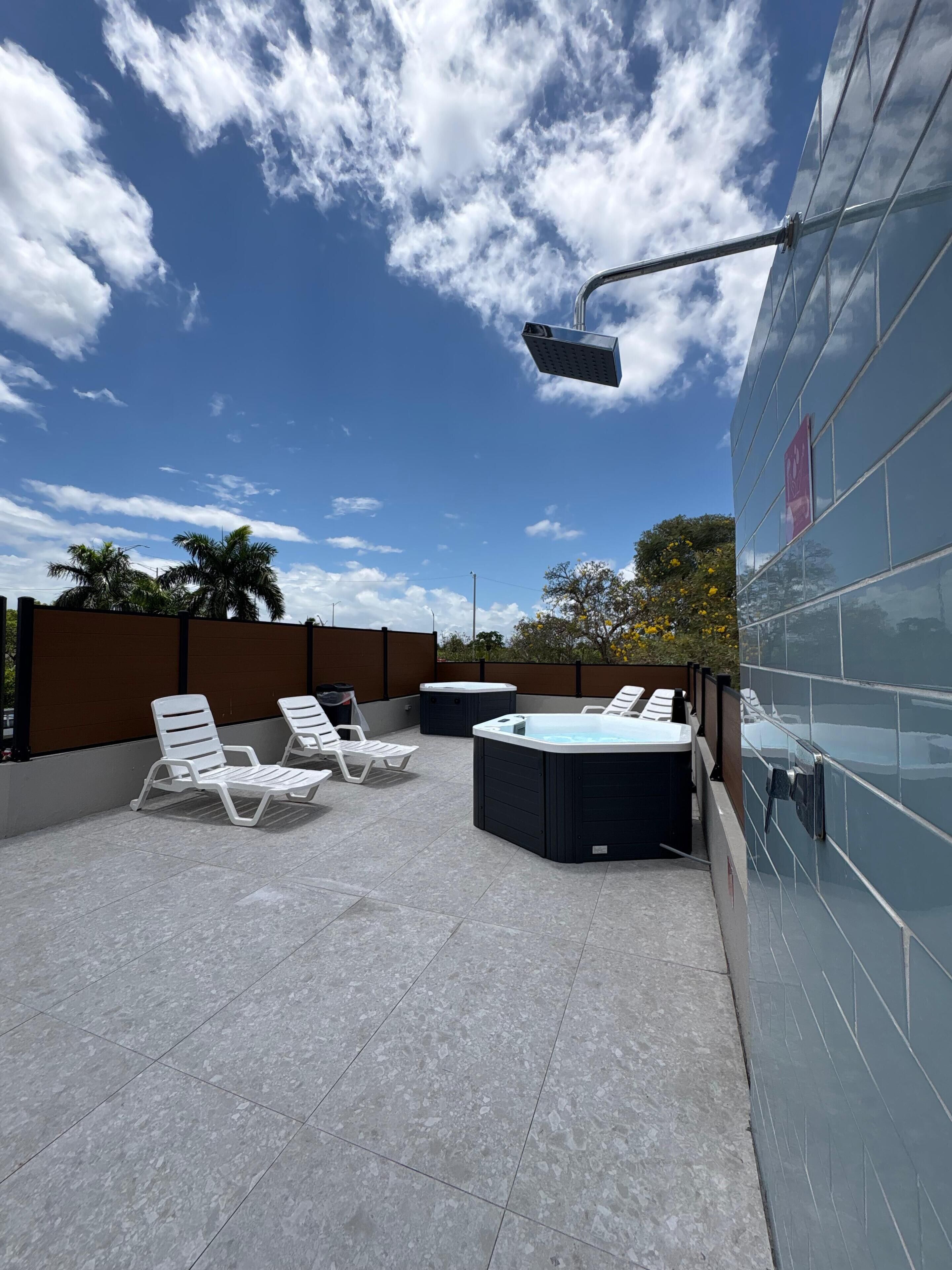 Una terrazza panoramica con poltrone relax, una vasca idromassaggio e una telecamera di sicurezza.