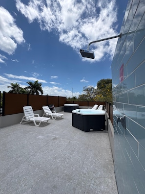 A rooftop terrace with lounge chairs, a hot tub, and a security camera. - Aura House Isla Verde (Carolina)