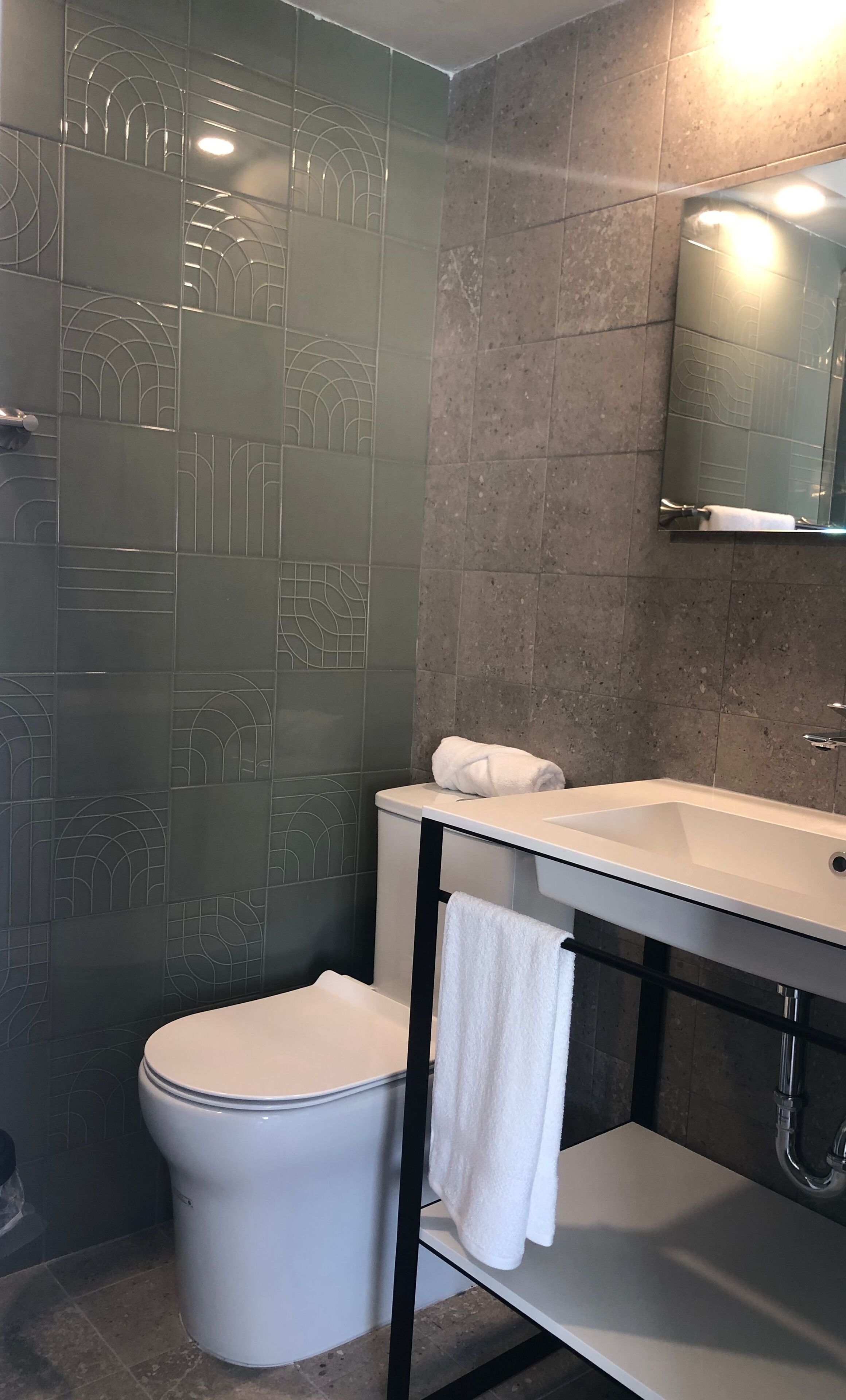 Une salle de bain avec des toilettes, un lavabo et un miroir.