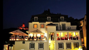 A hotel with a restaurant on the ground floor, featuring outdoor seating and a balcony. - Hotel & Restaurant La Baia (Cochem)