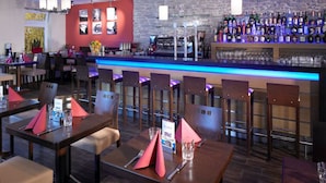 A bar area with multiple seating arrangements and a well-stocked bar counter. - Hotel & Restaurant La Baia (Cochem)