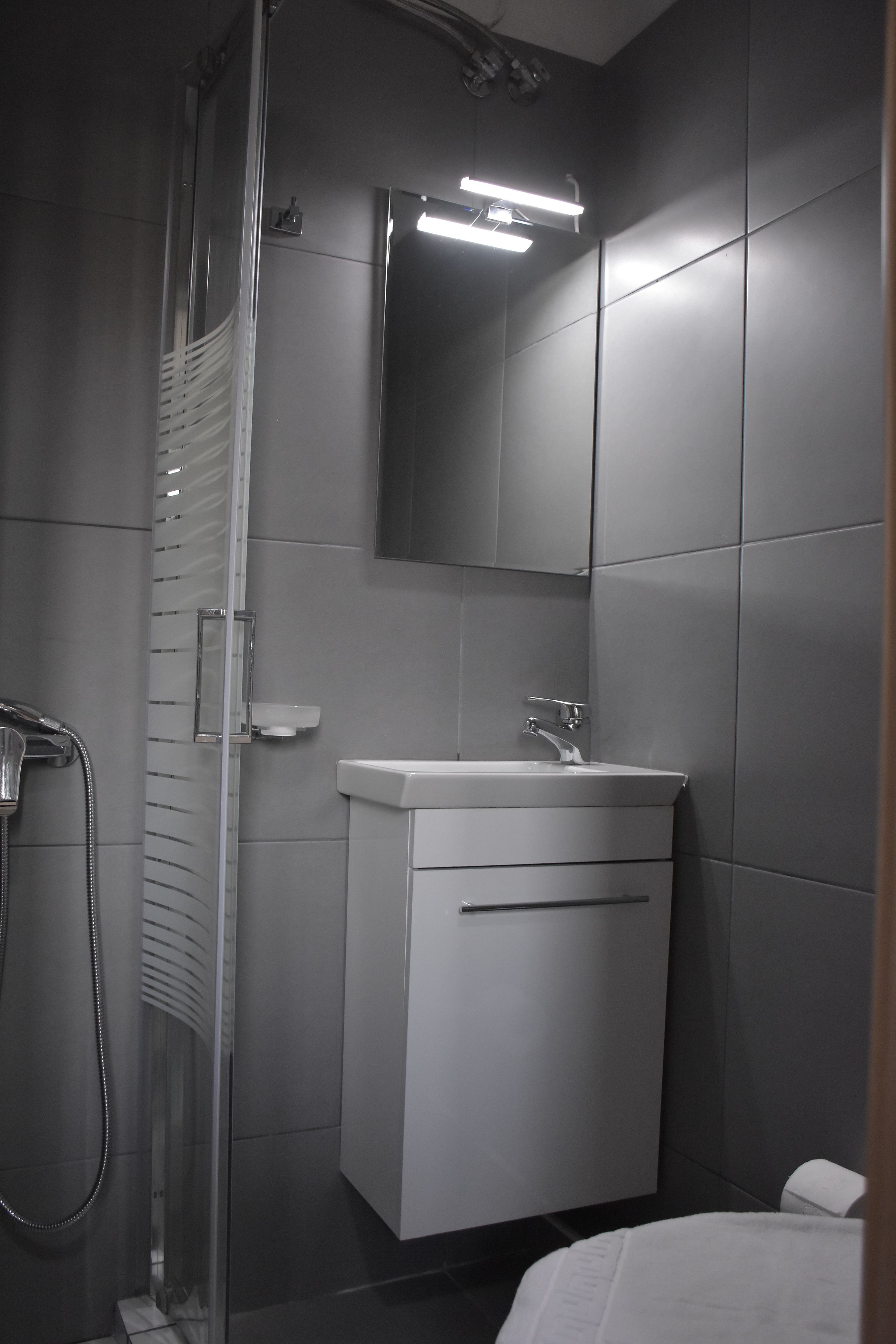 Studio | Badkamer | Een douche, een regendouche, een haardroger, handdoeken
