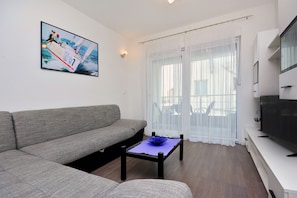 Relax in this stylish living room with a sofa, coffee table, and flat-screen TV.